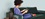 woman sitting on a couch looking at a tablet